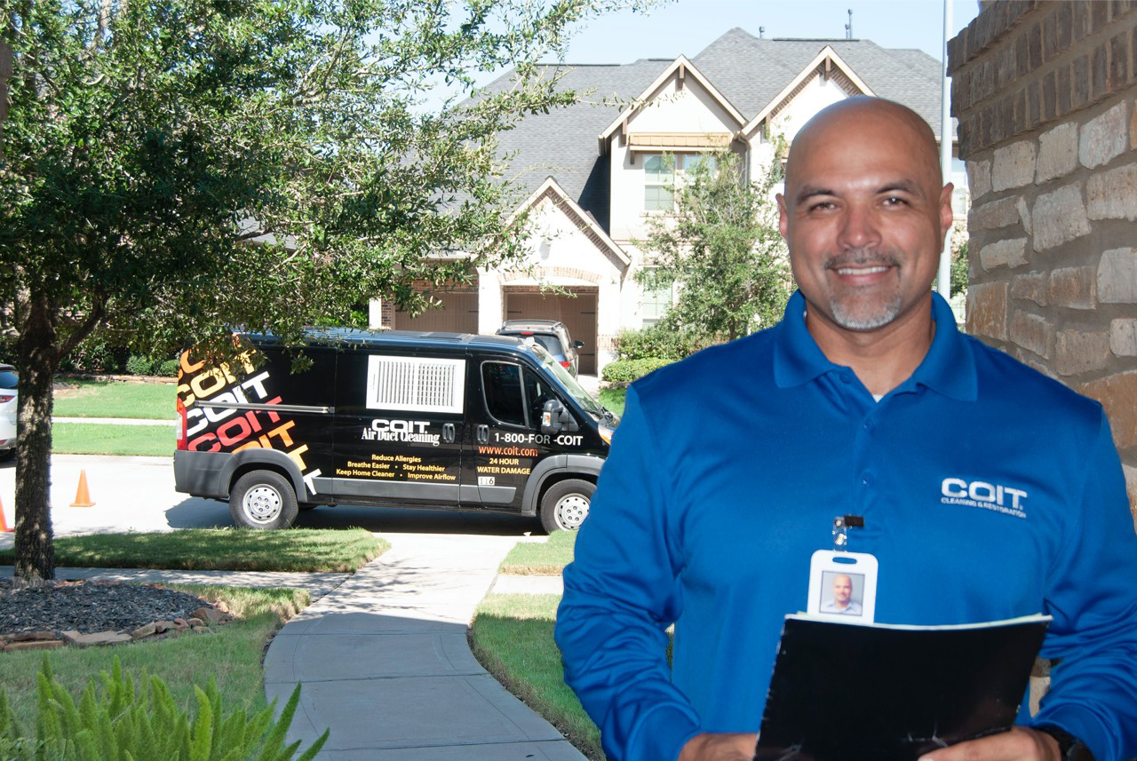 COIT technician standing at door with van behind him