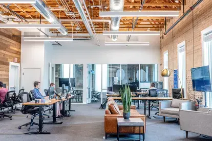 People sitting at desks in an open-office environment.